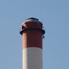 cordiste à Marseille réalisant le contrôle des bracons de passerelle d'une cheminée de centrale thermique