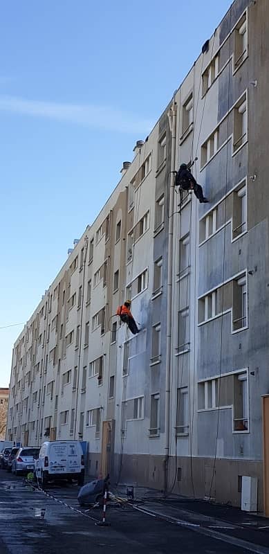 Cordiste de Marseille en travaux en hauteur de nettoyage haute pression de façade d'immeuble